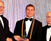 FIU hospitality alumnus Adam Stewart being presented with a Torch Award at the 10th annual event with FIU President Mark B. Rosenberg and Chaplin School's Rocco Angelo