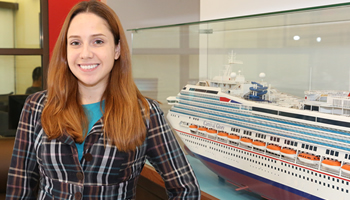 Student standing in front of model cruise ship