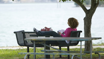 Student lounging on a picnic table next to Biscayne Bay